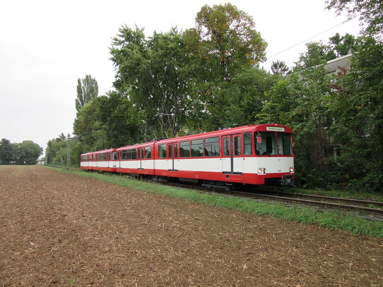 Sonderfahrt Rot-weiß Bahn auf einer Strecke vorbei am Acker und Bäumen